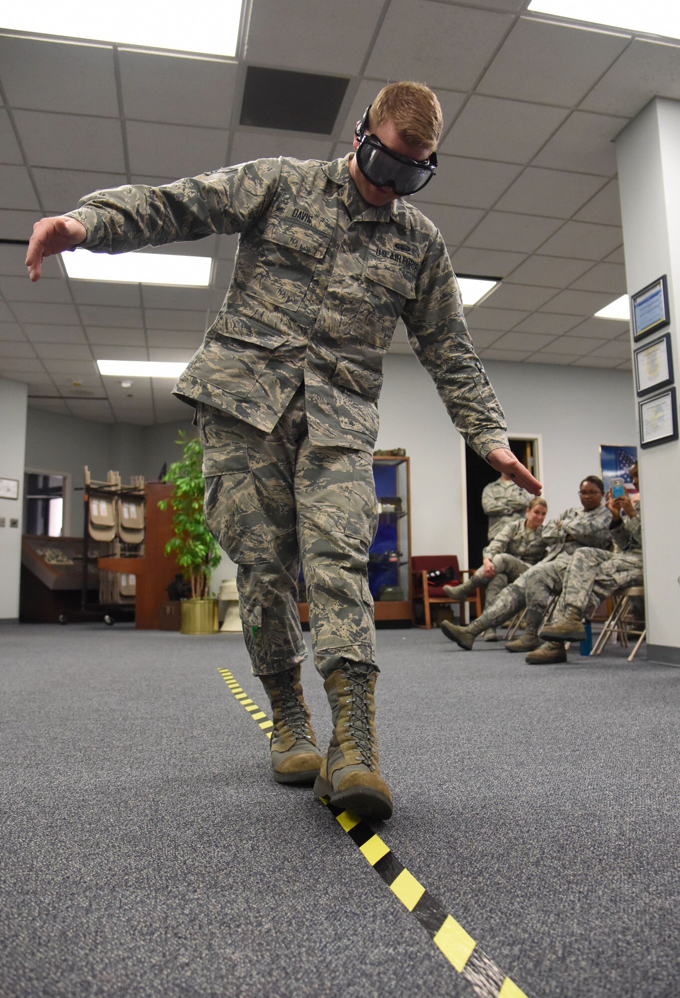 Airman 1st Class Larry Davis, 81st Communications Squadron client systems technician, is subjected to a field sobriety test while wearing drunk goggles during an alcohol awareness briefing at the 81st CS Dec. 19, 2017, on Keesler Air Force Base, Mississippi. December is Impaired Driving Awareness Month. More than 200 people were killed in Mississippi last year in drunk driving related incidents. (U.S. Air Force photo by Kemberly Groue)