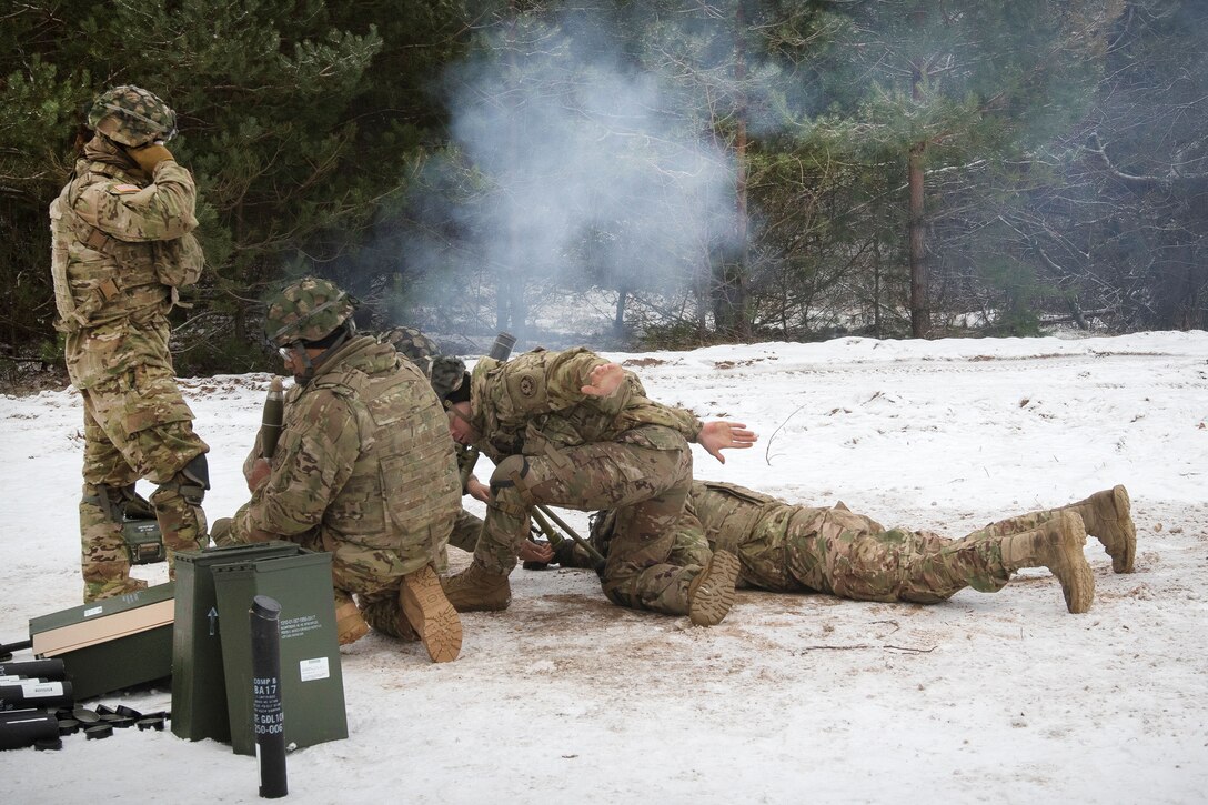 Soldiers fire a 60-millimeter mortar at a training area.