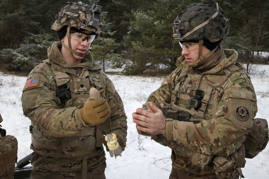 Army Spc. Clayton Caliguire, left, and instructs Sgt. Michael Kolis a Novi on the proper firing technique.