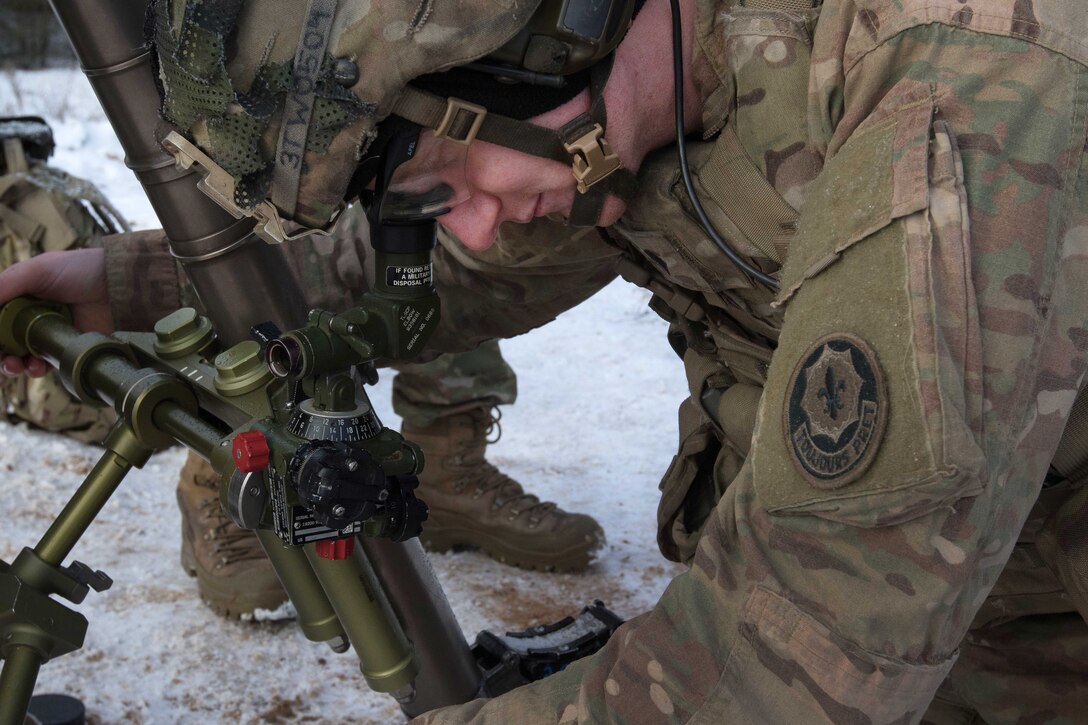 Army Spc. Taylor Wachman sights in and adjusts his team’s 60-millimeter mortar.