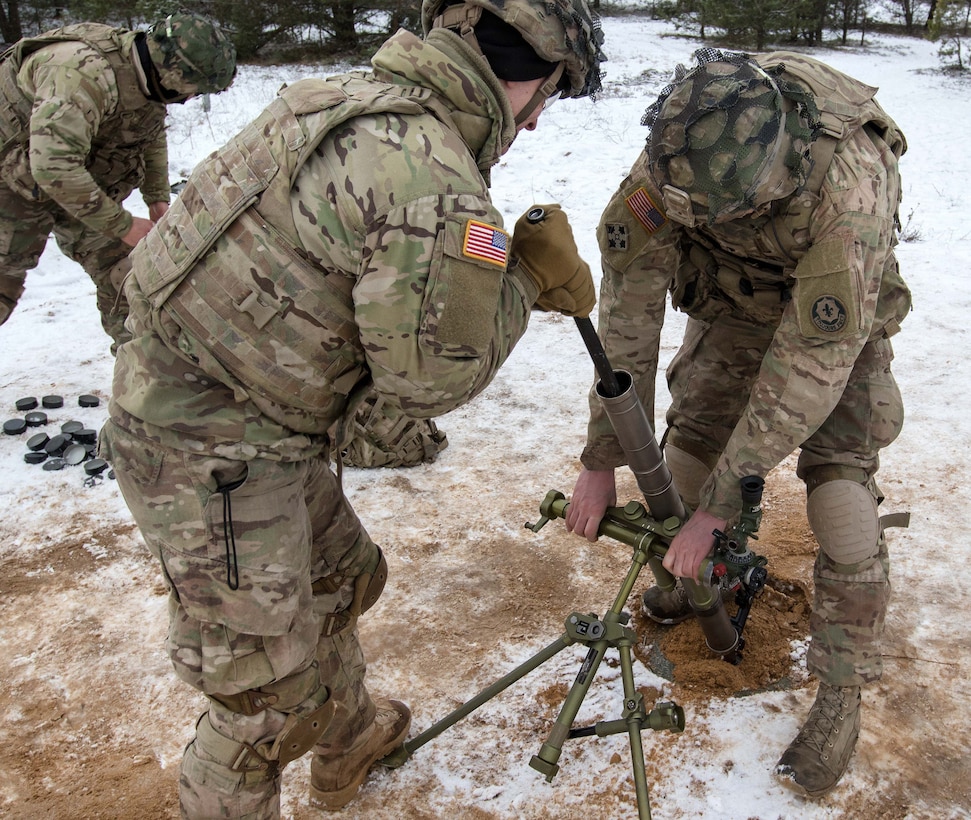 Soldiers clean their 60-millimeter mortar tube after a day of fire missions.