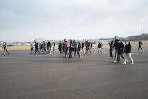 Members of Naval Medical Research Unit-Dayton conduct a foreign-object-damage walk-down Dec. 19, 2017, on the Wright-Patterson Air Force Base, Ohio, Area B flight line in advance of the arrival of a Marine Corps MV-22 Osprey aircraft. The unit was preparing the seldom-used runway near the National Museum of the Air Force for the arrival the plane that was signed over to the unit for medical research. (U.S. Air Force photo by R.J. Oriez)