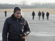Navy Cmdr. Tatana Olson, Naval Aerospace Medical Research Laboratory deputy director, joins her Naval Medical Research Unit-Dayton shipmates in a foreign-object-damage walk-down Dec. 19, 2017, on the Wright-Patterson Air Force Base, Ohio, Area B flight line in preparation for the arrival of a Marine Corps MV-22 Osprey aircraft. The aircraft was acquired by NAMRU-D to be used in research to minimize injuries to aircrew members. (U.S. Air Force photo by R.J. Oriez)
