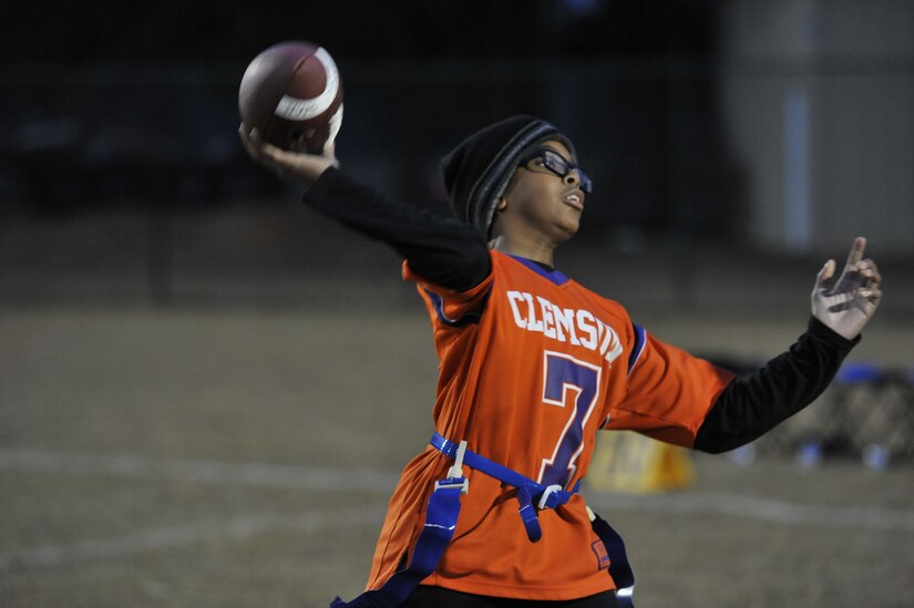 Andre, Weapons Station youth center participant, prepares to pass a football to one of his teammates Dec. 14, 2017, at Joint Base Charleston – Weapons Station, S.C.