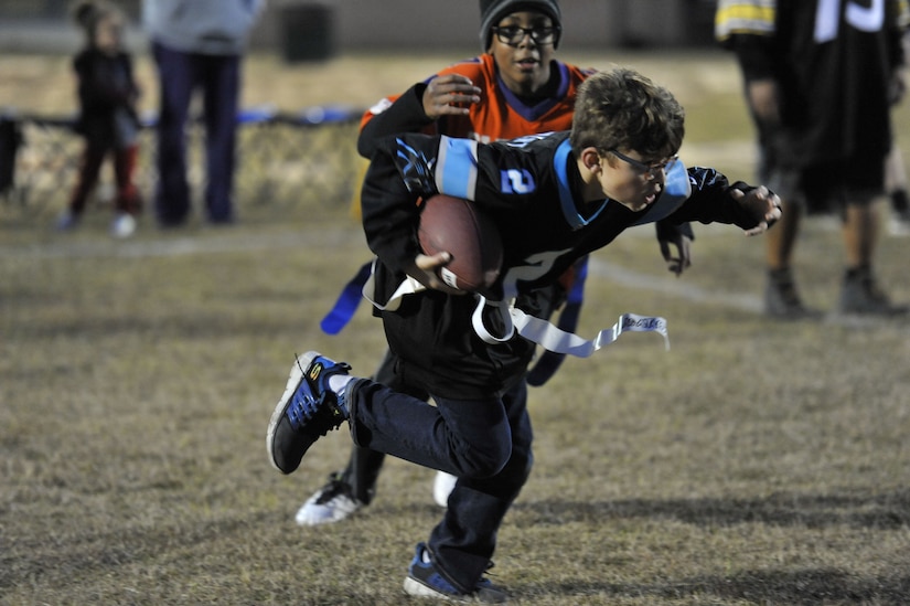 Andre, left, Weapons Station youth center participant, attempts to stop Everett, WS youth center participant, from making a touchdown Dec. 14, 2017, at Joint Base Charleston – Weapons Station, S.C.