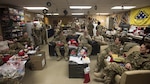 Members of the 455th Expeditionary Aeromedical Evacuation Squadron participate in a white elephant gift exchange Dec. 25, 2016 at Bagram Airfield, Afghanistan. The mission continued over the holiday, but service members took time to celebrate the holiday by talking with their families and spending time with their units.