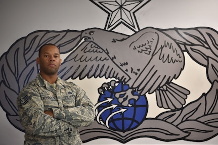 Tech. Sgt. Henry Robinson, 628th Logistics Readiness Squadron ground transportation vehicle operations control center support supervisor, poses in front of a mural of his unit’s occupational badge at the vehicle operations building on Joint Base Charleston, S.C., Dec. 20, 2017.