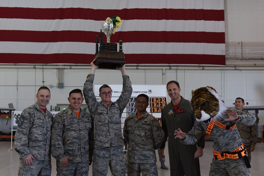 Col. Julian Cheater, 432nd Wing/Air Expeditionary Wing commander, and Chief Master Sgt. Jamie Auger, 432nd WG/AEW command chief, stand with the winners of the 432nd Aircraft Maintenance Squadron load crew of the quarter competition Dec. 8, 2017, at Creech Air Force Base, Nev. This quarter, participants wore full chemical suits while performing the mandatory tasks for their aircraft during the competition. (U.S. Air Force photo by Airman 1st Class Haley Stevens)