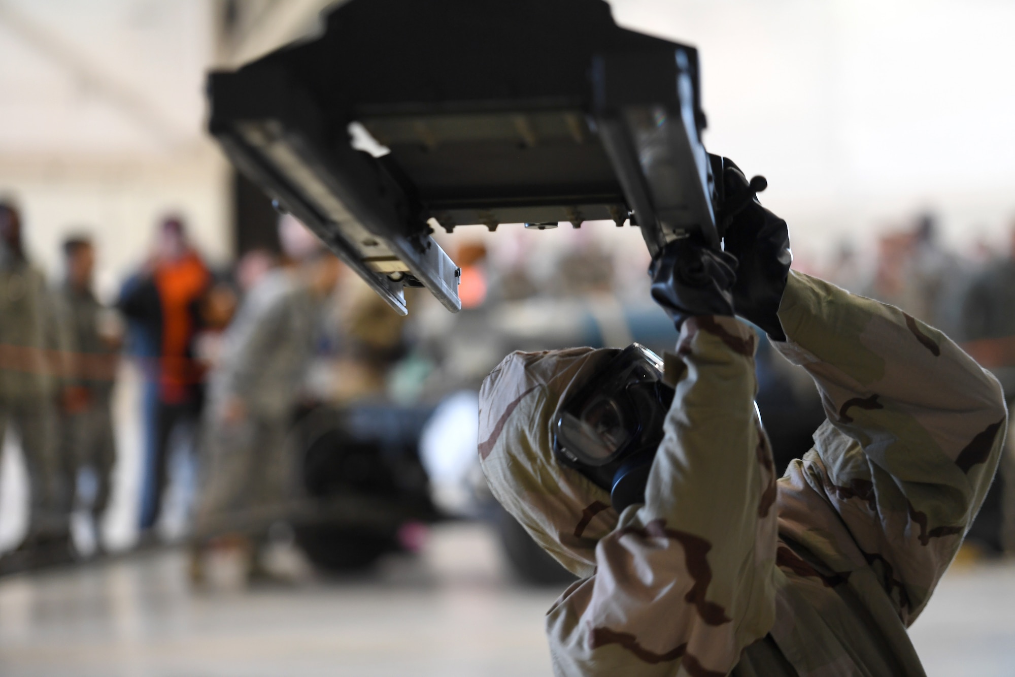 An Airman assigned to the 432nd Aircraft Maintenance Squadron Tiger Aircraft Maintenance Unit prepares to load a GBU-38 Joint Direct Attack Munition during a weapons load competition Dec. 8, 2017, at Creech Air Force Base, Nev. This was the first weapons load that required participants to wear full chemical, biological, radiological, nuclear and explosives gear in more than three years. (U.S. Air Force photo by Senior Airman James Thompson)