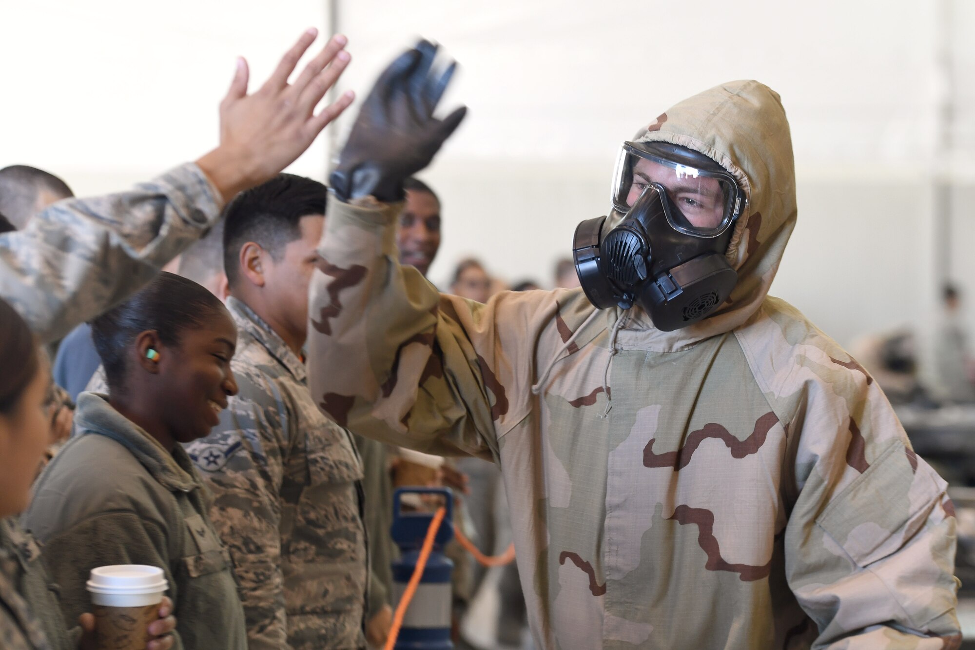 An Airman assigned to the 432nd Aircraft Maintenance Squadron Tiger Aircraft Maintenance Unit celebrates with audience members after winning the weapons load competition Dec. 8, 2017, at Creech Air Force Base, Nev. The 432nd Wing set programs such as chemical, biological, radiological, nuclear and explosives training in place to prepare MQ-1 Predator and MQ-9 Reaper aircrews to win a fight in any condition. (U.S. Air Force photo by Senior Airman James Thompson)