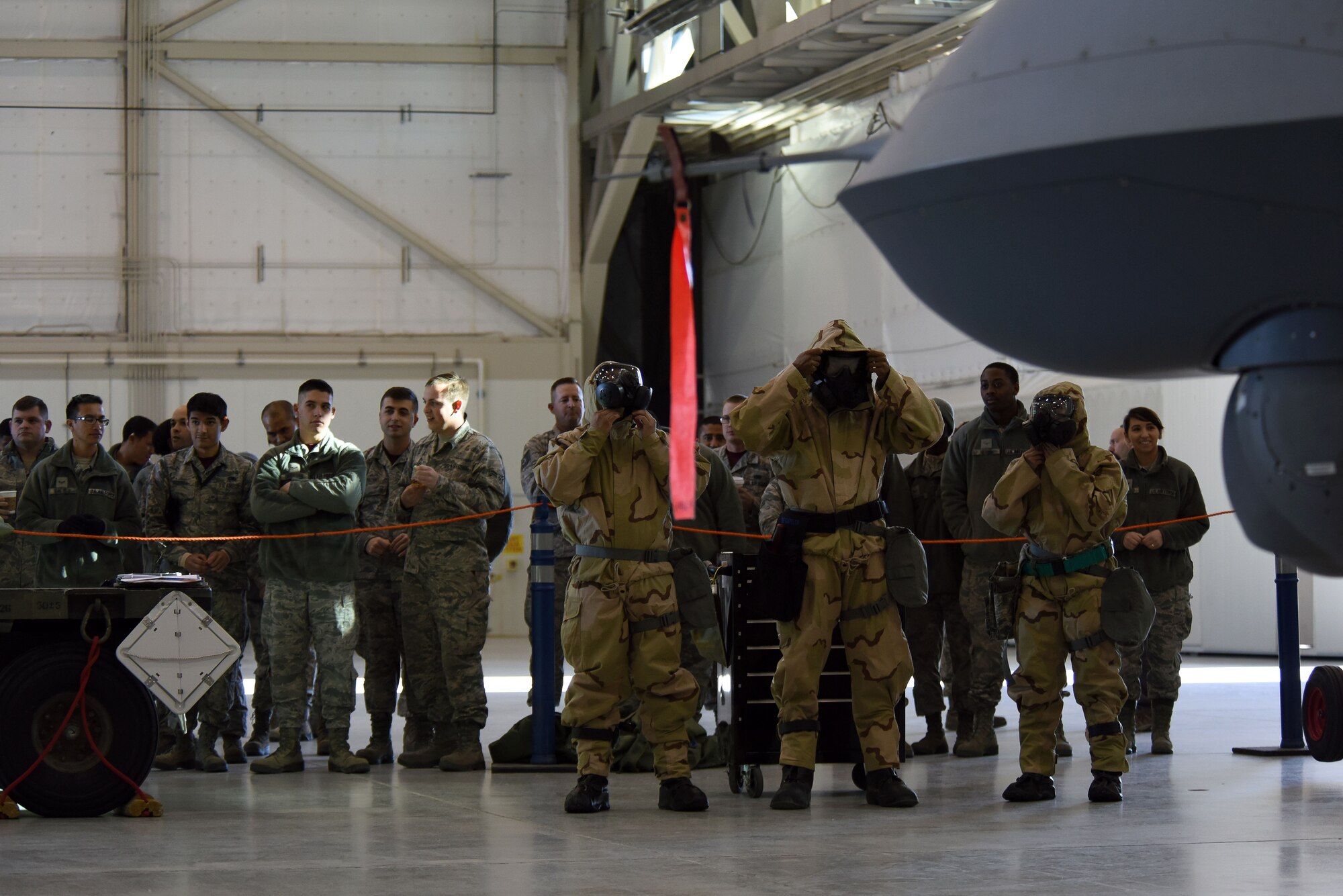 Airmen assigned to the 432nd Aircraft Maintenance Squadron Reaper Aircraft Maintenance Unit don their masks before a weapons load competition Dec. 8, 2017, at Creech Air Force Base, Nev. Chemical, biological, radiological, nuclear and explosives gear covers and protects as much of the body as possible in the event of chemical or biological warfare. (U.S. Air Force photo by Airman 1st Class Haley Stevens)