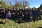 Service members and civilians pose for a photo.