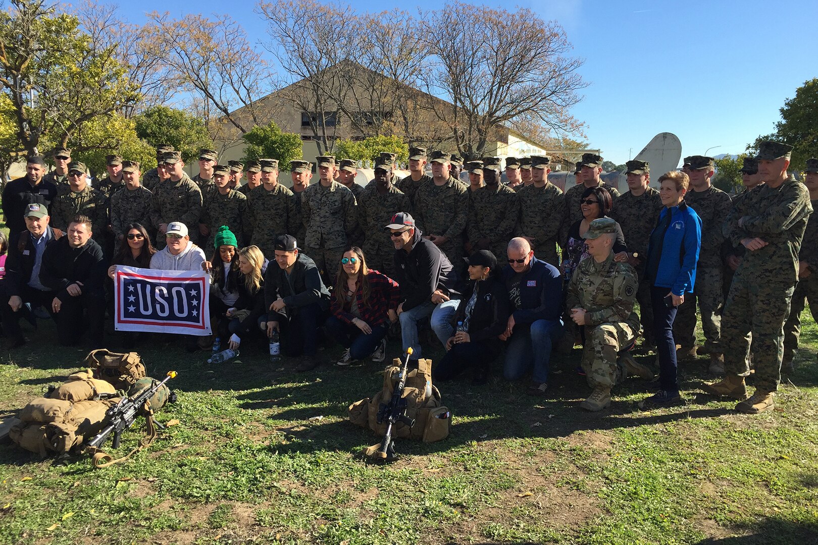 Service members and civilians pose for a photo.