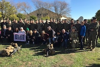 Service members and civilians pose for a photo.