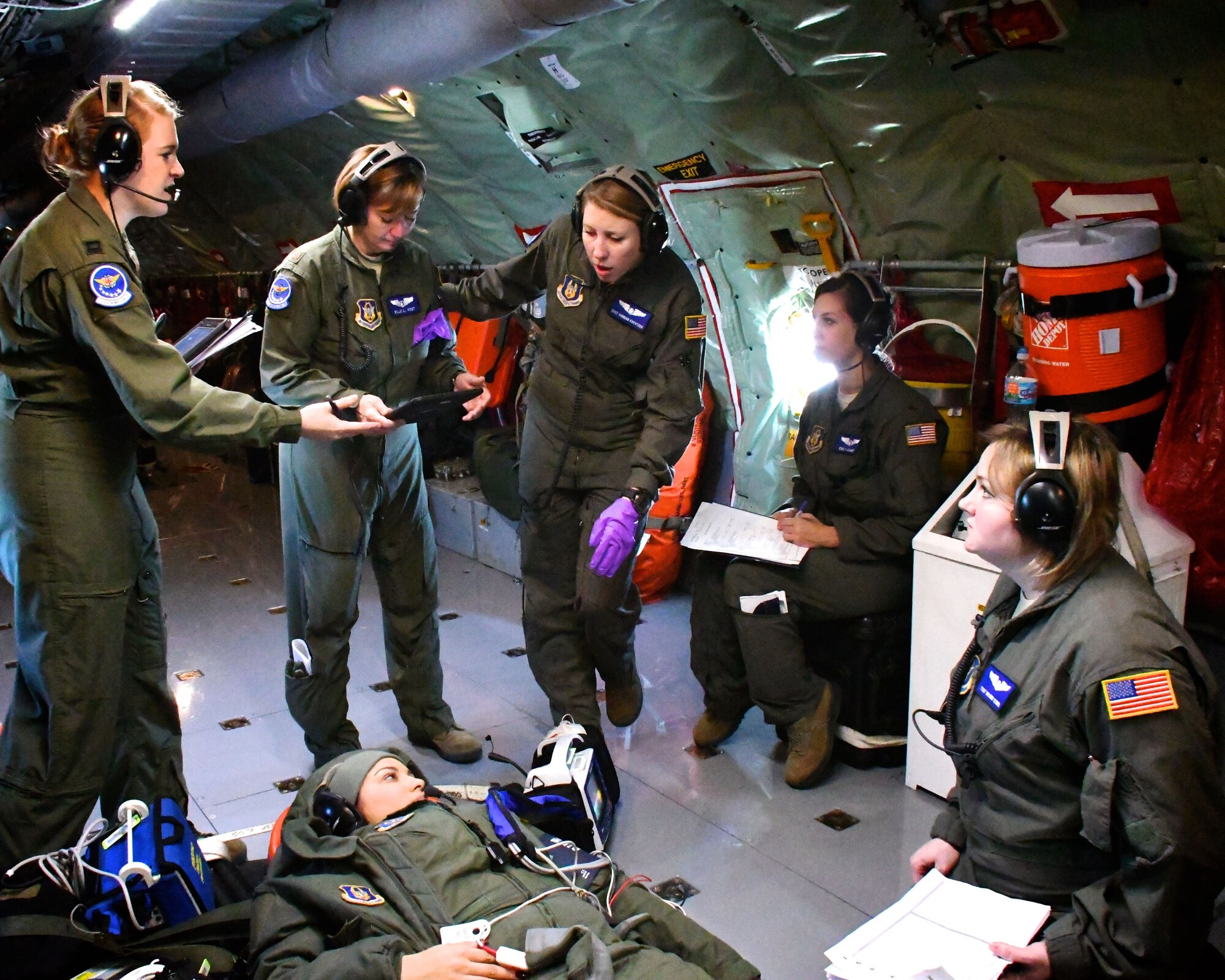 Flight nurses and medical technicians of the 932nd Aeromedical Evacuation Squadron, located at Scott Air Force Base, Ill., discuss over radio headsets how to care for a simulated practice patient during a training flight Dec. 17, 2017.  They flew a scheduled training flight, to get experience in the air, courtesy of the 507th Air Refueling Wing aircrew aboard a KC-135 plane.  This gave them a chance to provide upgrade training and refresher skills to several Airmen, separately from unit training assembly weekends.  The 932nd Airlift Wing is a 22nd Air Force unit, under the Air Force Reserve Command.  (U.S. Air Force photo by Lt. Col. Stan Paregien)