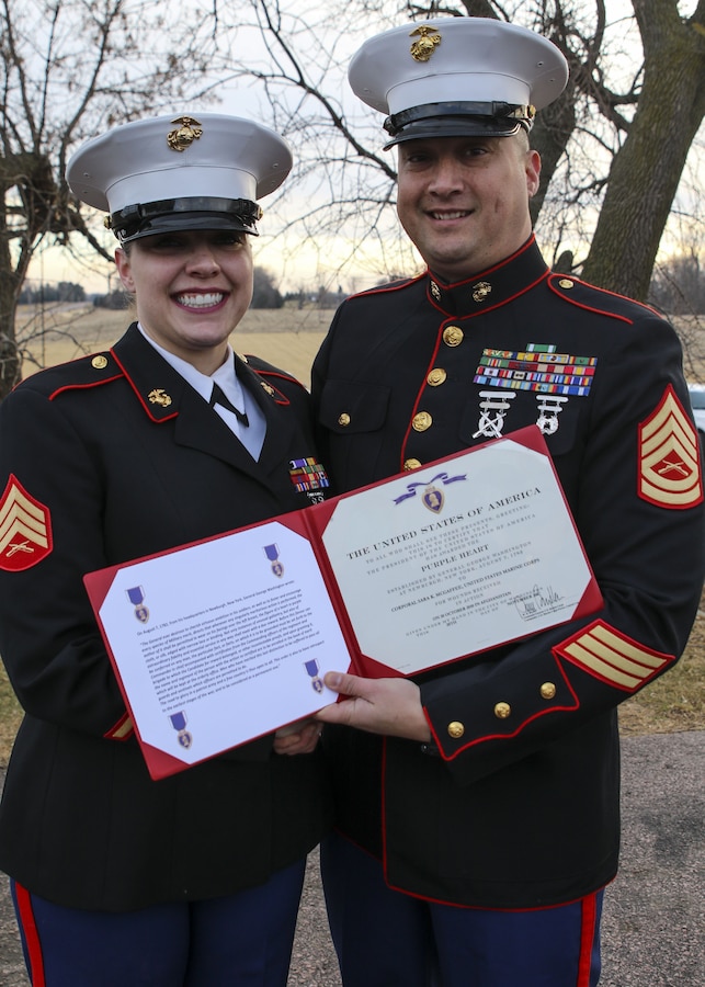 Gunnery Sgt. Paul Odonnell, the staff noncommissioned officer in charge of Marine Corps Recruiting Sub Station Sioux Falls, posed for a photo with Sgt. Sarah McGaffee, a Sioux Falls, S.D., native, after presenting her with the Purple Heart Medal. On Oct. 20th, 2010, while deployed with Combat Logistics Battalion 3, McGaffee’s vehicle was hit by an improvised explosive device while conducting convoy operations in support of Operation Steel Dawn II in the Helmand province of Afghanistan. McGaffee was awarded her Purple Heart, Dec. 16, 2017 in Sioux Falls, S.D., in front of a detail of Marines and her local friends and family.