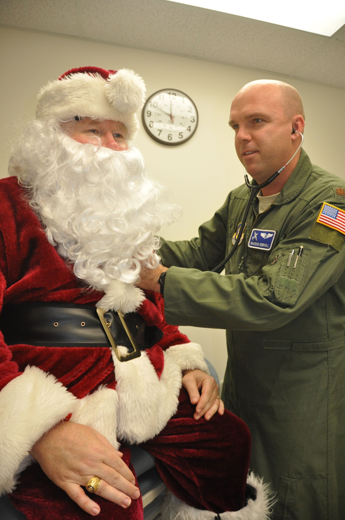 Major Brandon Hemphill, Flight Surgeon with the 908th Airlift Wing's 357th Airlift Squadron conducts a flight physical for Santa Claus at the Maxwell Clinic on Maxwell Air Force Base, Ala., Dec. 2.