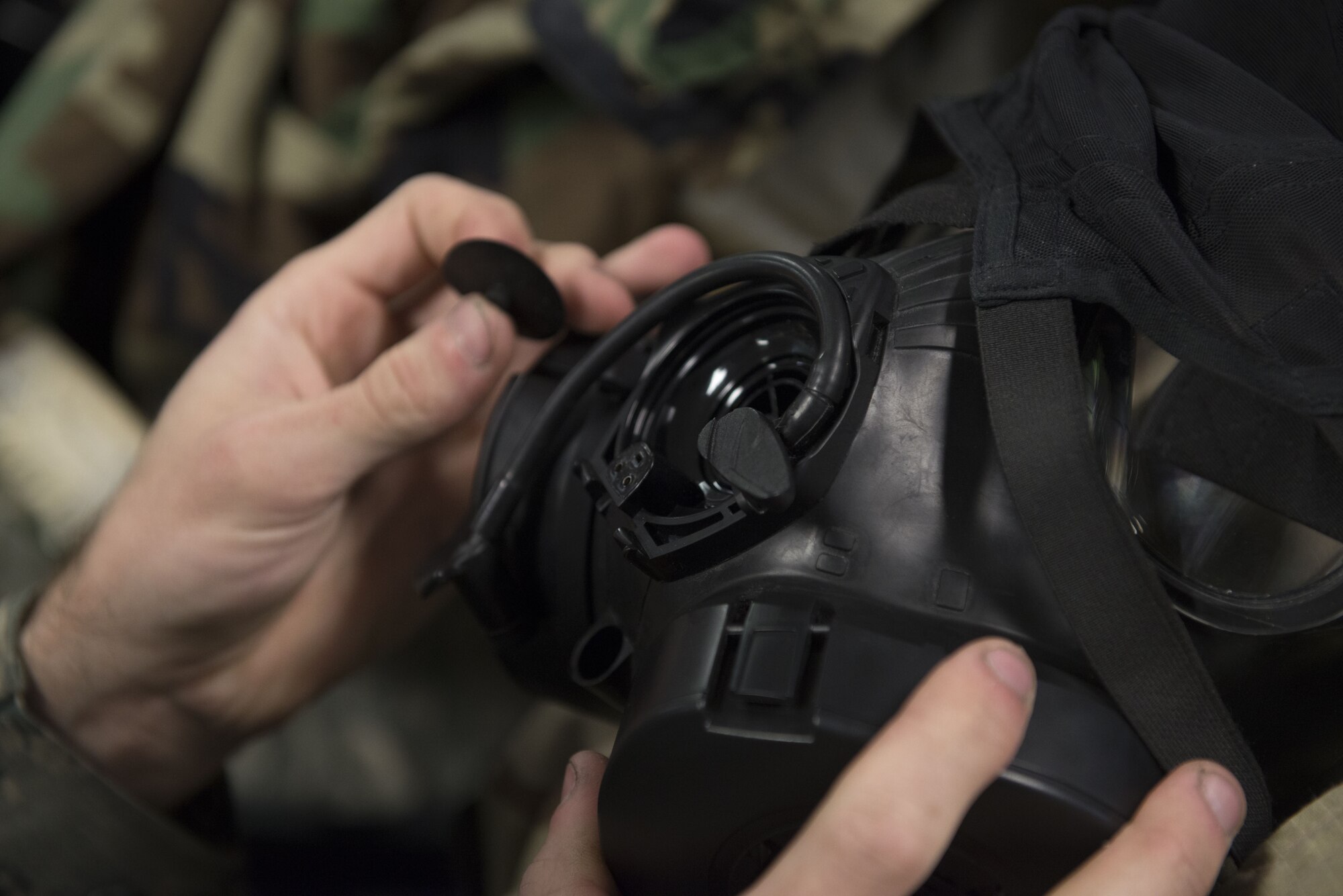 A 366th Fighter Wing Airman checks the inlet/outlet disk valve on his gas mask during chemical, biological, radiological, nuclear and explosives training Dec. 20, 2017, at Mountain Home Air Force Base, Idaho. CBRNE training prepares Airmen to survive and work in a harmful environment anywhere in the world. (U.S. Air Force photo by Airman 1st Class JaNae Capuno)