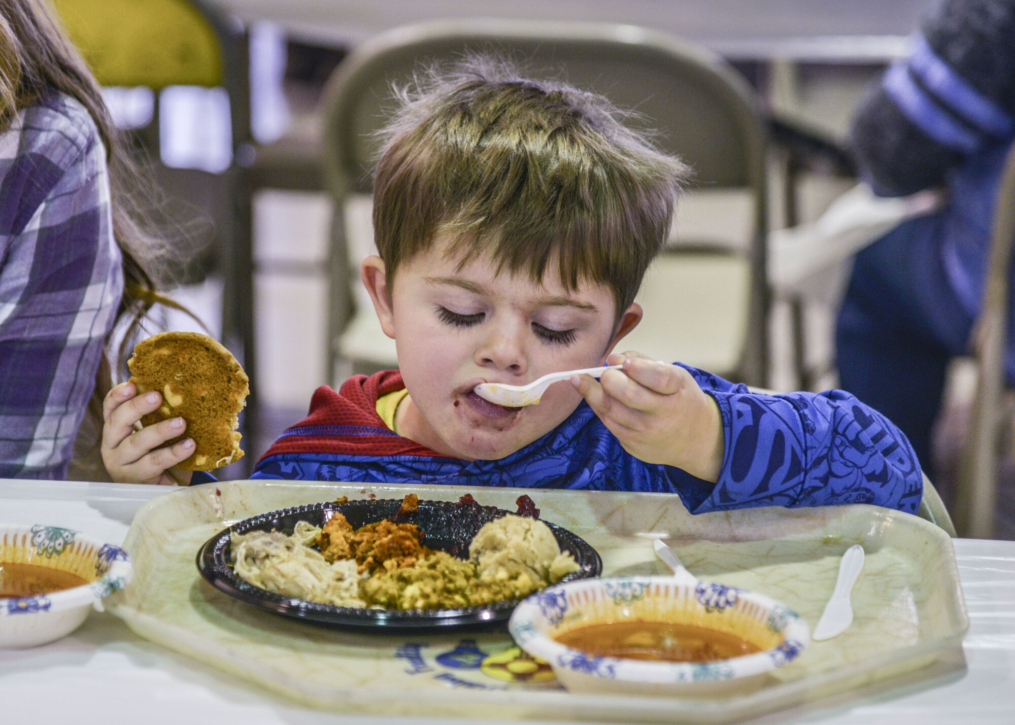 A child eats his holiday meal at the annual Operation Holiday Cheer on Dec. 20 at Kirtland Air Force Base, New Mexico. This event is hosted by the Kirtland Fire Department and serves underprivileged families in the local communities by giving them a full holiday meal and a visit with Santa, who sends them home with a gift.
