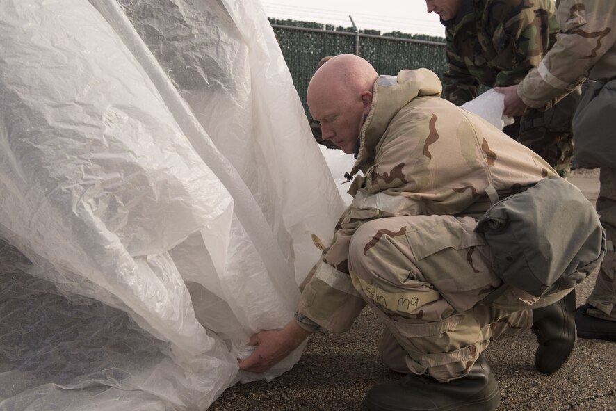 Tech. Sgt. Brian Medley, 366th Equipment Maintenance Squadron metals technology section chief, places a plastic cover over a vehicle during chemical, biological, radiological, nuclear and explosives training Dec. 20, 2017, at Mountain Home Air Force Base, Idaho. CBRNE training prepares Airmen to survive and work in a harmful environment anywhere in the world. (U.S. Air Force photo by Airman 1st Class JaNae Capuno)