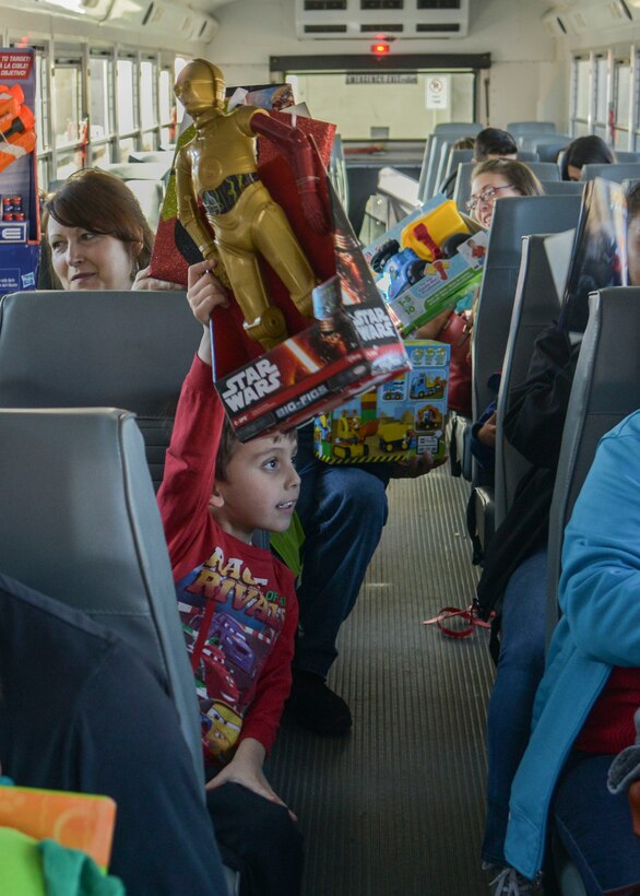 Children proudly display what Santa gave them at the annual Operation Holiday Cheer event on Dec. 20th, 2017 at Kirtland Air Force Base, New Mexico.  This event serves underprivileged families in the local communities by giving them a full holiday meal, a visit with Santa, and sending the children home with gifts.