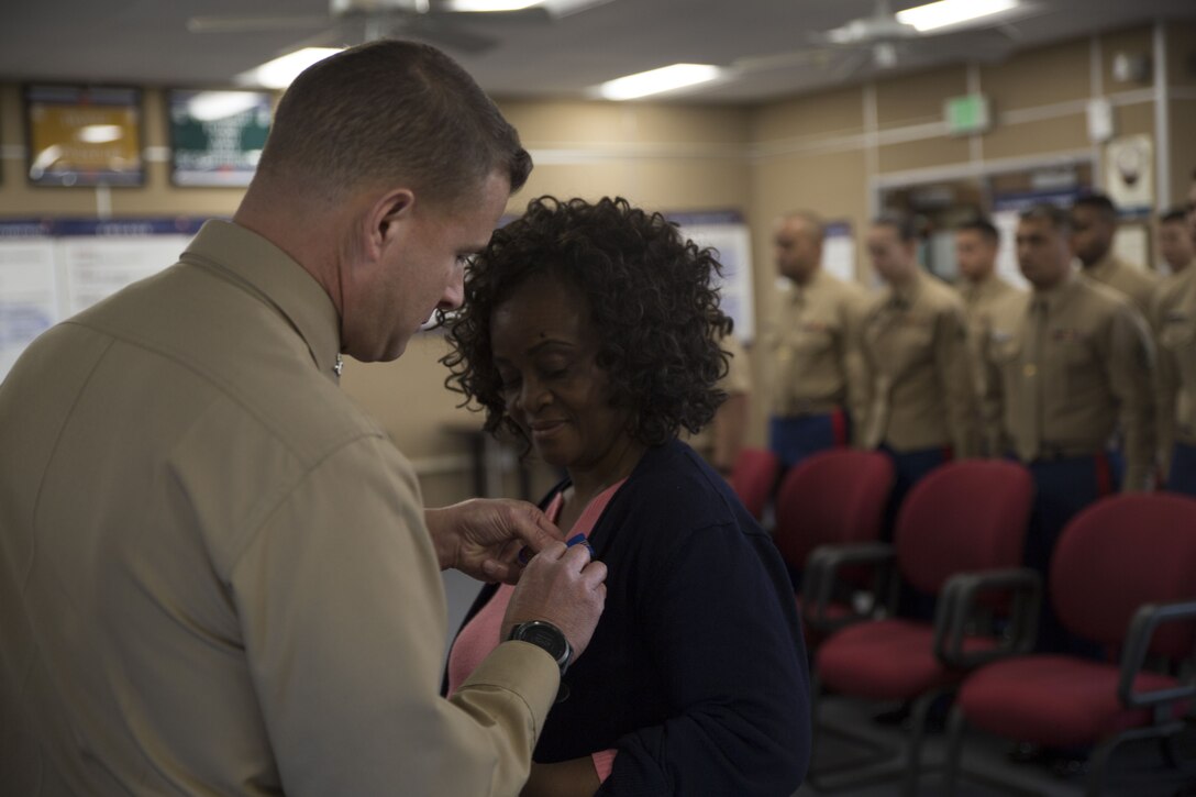 U.S. Marine Corps Col. Terry M. Johnson, Commanding Officer, 12th Marine Corps District, Marine Corps Recruit Depot, San Diego, presents Ms. Gloria Pettis with a Commendation for Meritorious Civilian Service Medal for her 36 years of faithful and dedicated federal service, Dec. 21, 2017. Ms. Pettis served as the Financial Management Analyst for the 12th Marine Corps District for almost 25 years.