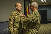 Maj. Jason Engelbrecht, future operations officer, Joint Task Force Civil Support receives a Defense Meritorious Service medal from Maj. Gen. Richard Gallant, commander, JTF-CS December 20, 2017.