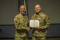 Maj. Jason Engelbrecht, future operations officer, Joint Task Force Civil Support receives a Defense Meritorious Service medal from Maj. Gen. Richard Gallant, commander, JTF-CS December 20, 2017.