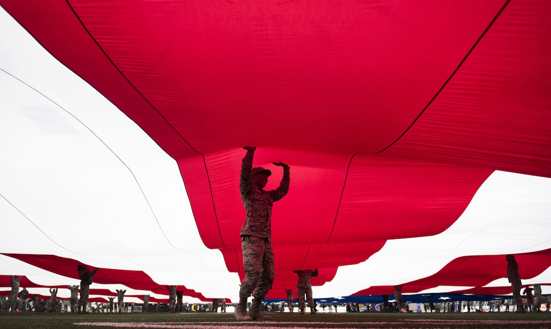 Airman Bonifacio Garcia, 757th Aircraft Maintenance Squadron crew chief, and Airmen from Nellis and Creech Air Force Bases, hold up a 100-yard flag during rehearsal for the 2017 Las Vegas Bowl in Sam Boyd Stadium, Dec. 16, 2017 in Las Vegas. Approximately 150 Airmen volunteered to hold the flag for the pre-game ceremony. (U.S. Air Force photo by Senior Airman Kevin Tanenbaum)