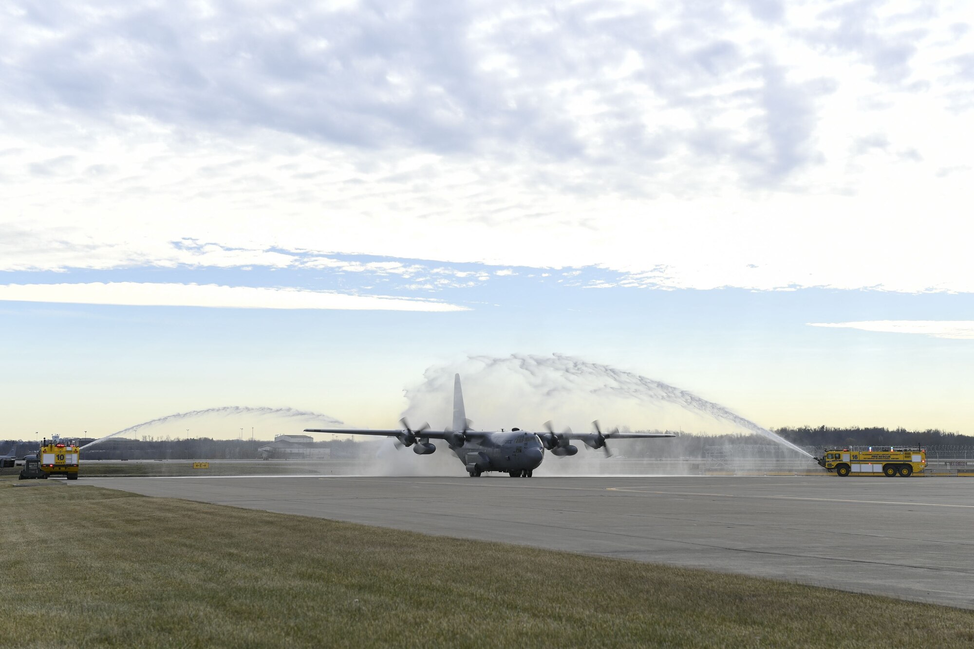 A C-130 Hercules assigned to the 911th Airlift Wing is sprayed by water as is passes by fire trucks at the Pittsburgh International Airport Air Reserve Station, Pennsylvania, December 21, 2017. The aircraft was returning from 758th Airlift Squadron flight engineer superintendent Chief Master Sgt. Bruce Bair’s Fini Flight, an Air Force tradition to honor the last flight of a member’s career. (U.S. Air Force photo by Senior Airman Beth Kobily)