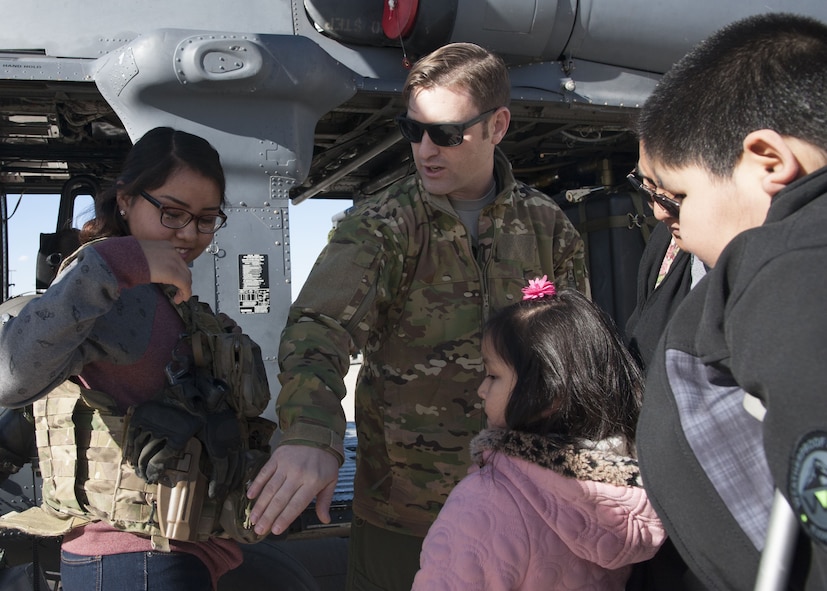 Tech. Sgt. Derek Brock, 58th Special Operations Wing special mission aviator instructor explains his body armor configuration to visitors from the Presbyterian and University of New Mexico children's hospital, at Kirtland Air Force Base, N.M., Dec. 21.