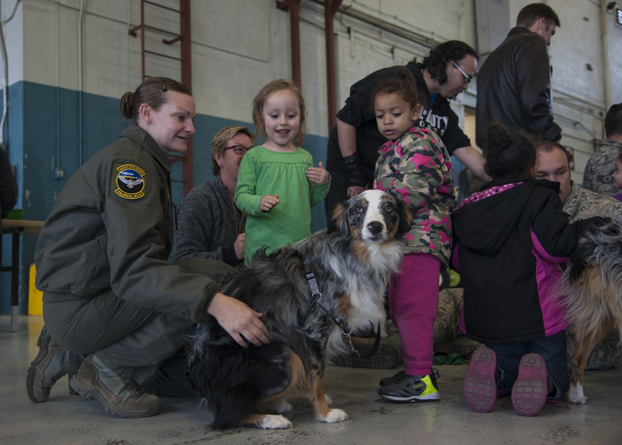 Tech. Sgt. Megan Freeman, 415th Special Operations Squadron first sergeant, pets a puppy with visitors from the Presbyterian and University of New Mexico children's hospital at Kirtland Air Force Base, N.M., Dec. 21.