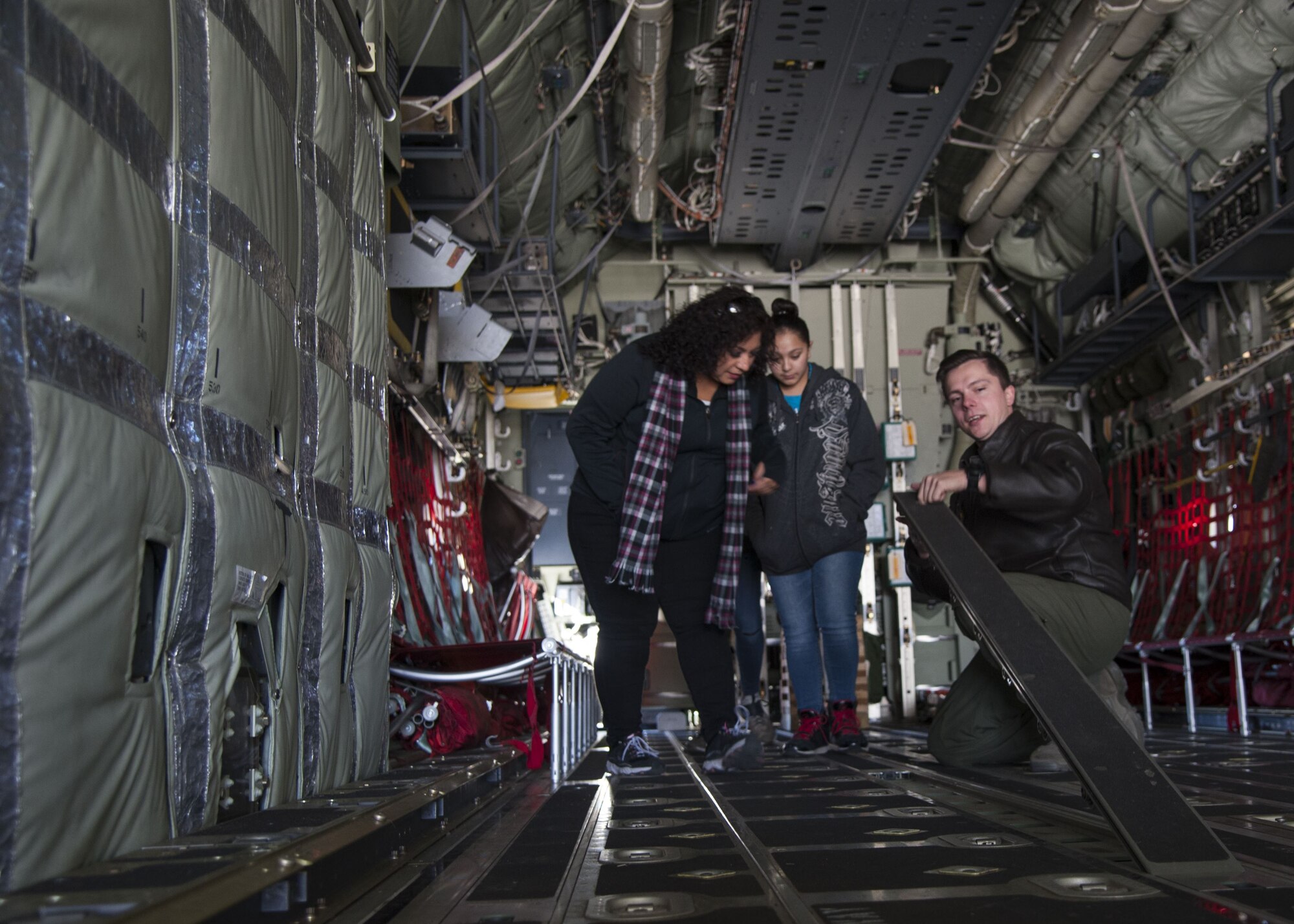 Staff Sgt. Zach Harmon, 58th Special Operations Wing MC-130J loadmaster, demonstrates how to change floor panels on the MC-130J to visitors from the Presbyterian and University of New Mexico children's hospital, at Kirtland Air Force Base, N.M., Dec. 21.