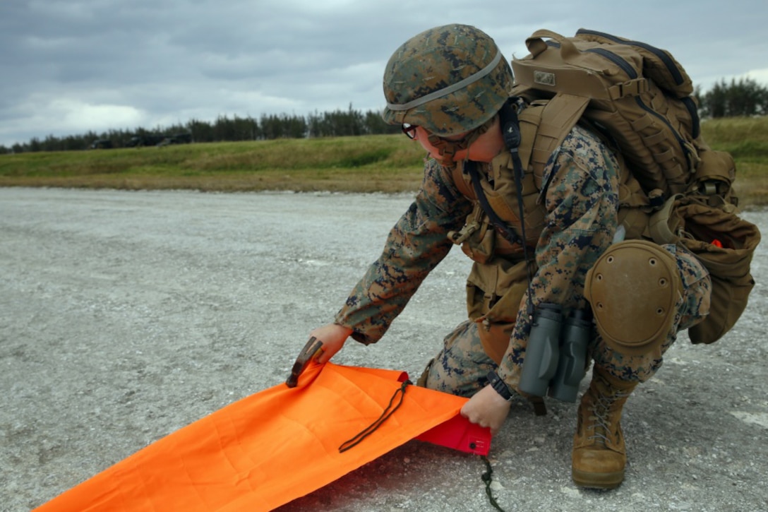 A Marine secures a panel that will notify an aircraft where to land during Exercise Voodoo Magic on Iejima Island in Okinawa, Japan.