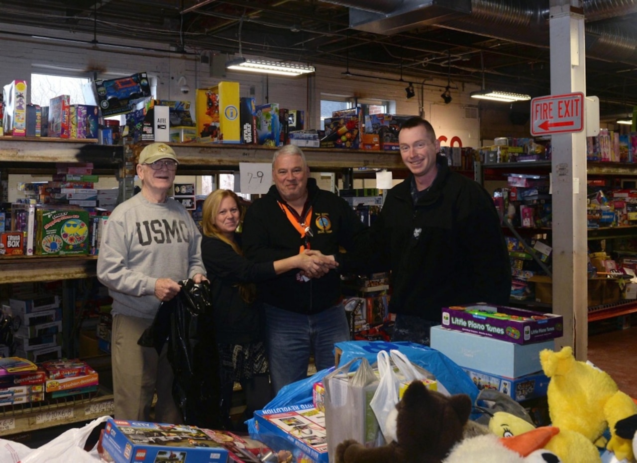 Navy Petty Officer 1st Class Scott Gold, right, assigned to the Virginia-class submarine Precommissioning Unit PCU Colorado, delivers donations to the Marine Corps League’s Thames River Detachment on behalf of the Colorado’s crew to support a Toys for Tots-sponsored charity event in Groton, Conn.