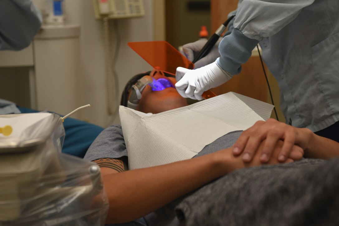 A dental curing light is scanning along the crown recently placed inside the patient’s mouth at the dental clinic at F.E. Warren Air Force Base, Wyo., Dec. 19, 2017. The light helps set the crown and sealant into place and is one of the final steps to replace a tooth’s crown. The mission of the U.S. Air Force Dental Corps is to achieve superior oral health and global readiness through safe, effective and patient-centered care. (U.S. Air Force photo by Airman 1st Class Abbigayle Wagner)