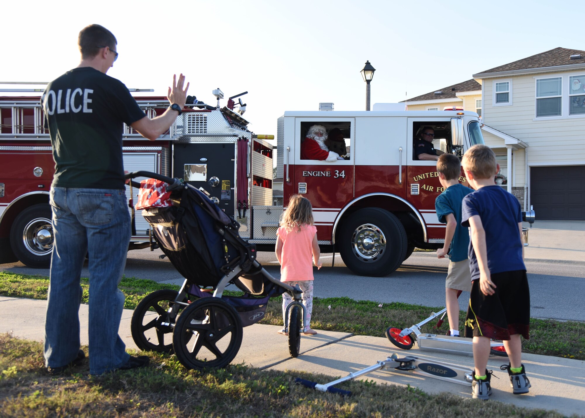Santa throws candy to children from a fire truck in Bay Ridge housing Dec. 21, 2017, on Keesler Air Force Base, Mississippi. Santa and fire department members drove through each housing area to spread Christmas cheer to Airmen and their families. (U.S. Air Force photo by Kemberly Groue)