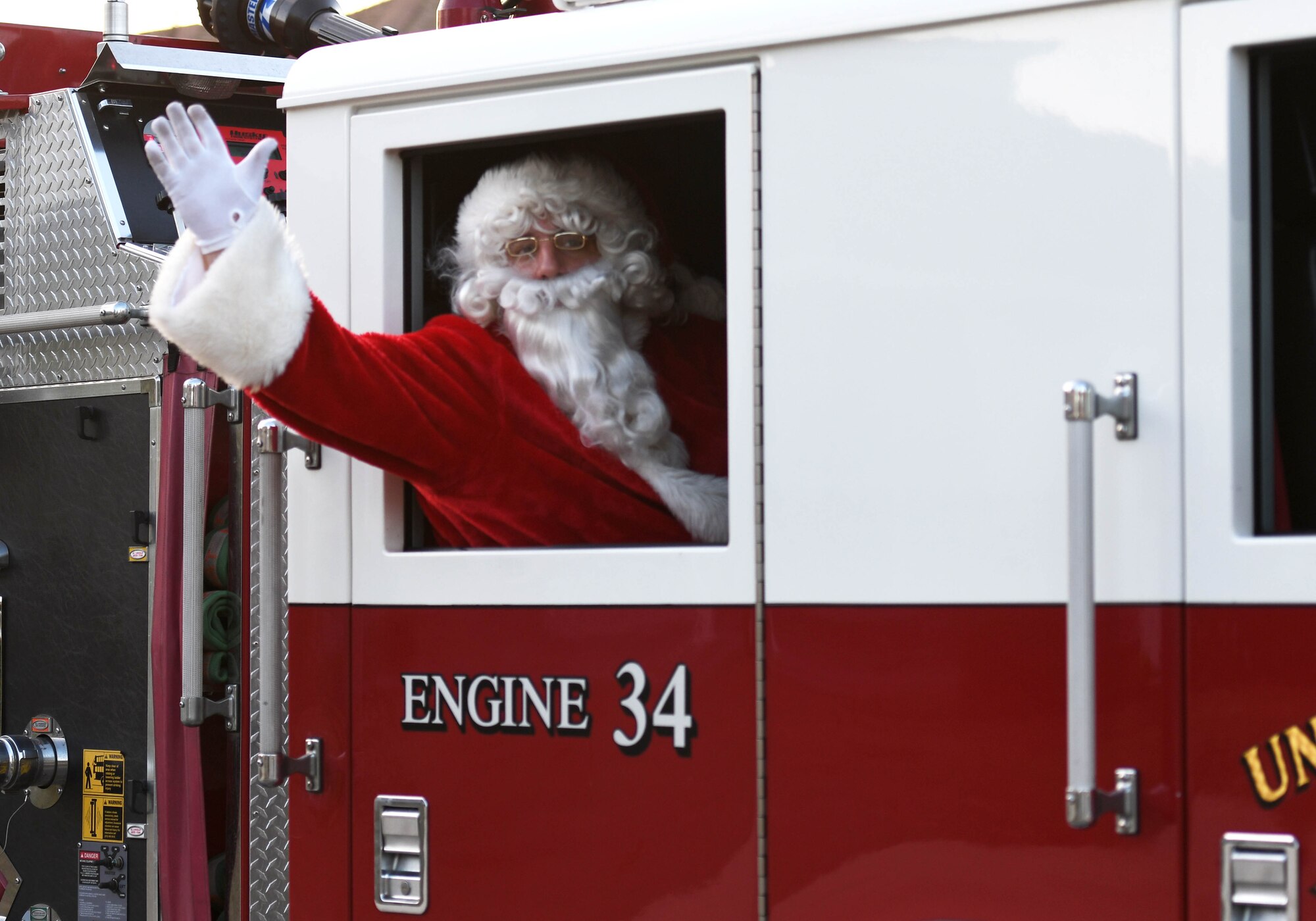 Santa waves to children from a fire truck in Bay Ridge housing Dec. 21, 2017, on Keesler Air Force Base, Mississippi. Santa and fire department members drove through each housing area to spread Christmas cheer to Airmen and their families. (U.S. Air Force photo by Kemberly Groue)