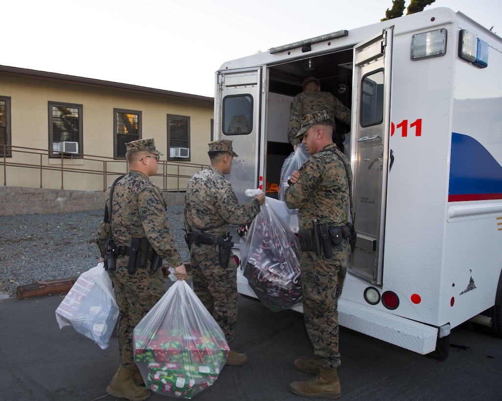 Marines and police officers with the Provost Marshal’s Office, deliver gifts to Stuart Mesa housing families during the 2nd annual “Cops for Kids” event on Camp Pendleton, Calif., Dec. 19, 2017. 1st Lt. Mark Crum and Cpl. Anthony James organized the event in conjunction with Toys for Tots an effort to give back to the community and build awareness of law enforcement initiatives aboard the installation. (U.S. Marine Corps photo by Pfc. Drake Nickels)