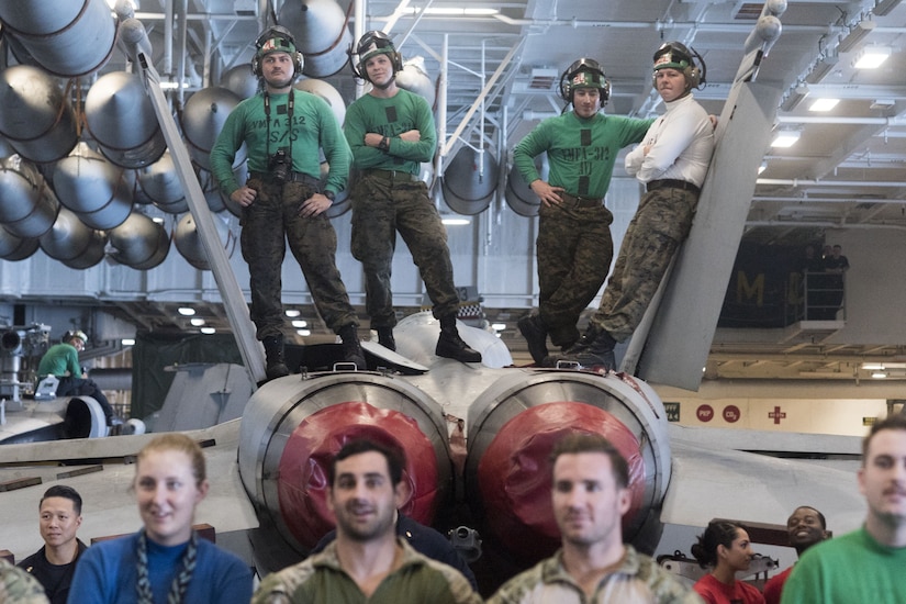 Marines watch a USO show from the top of an F/A-18F Super Hornet.