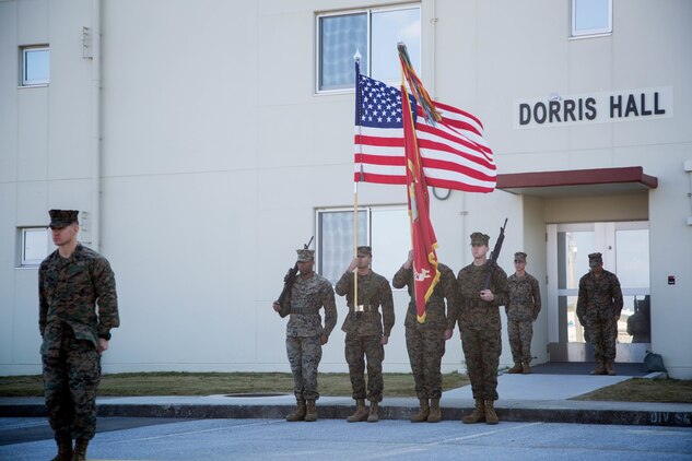 Marines from 3rd Marine Division, Camp Courtney, Okinawa, Japan, stand at attention as a sign of respect during the revealing of the staff non-commissioned officer barracks’ name on Camp Courtney, Okinawa, Japan, Dec. 22, 2017. Dorris Hall is named after the Navy Cross recipient, Staff Sgt. Claude H. Dorris, a squad leader with the Combined Action Program during the Vietnam War, who went above and beyond the call of duty.