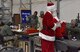 A service member dressed as Santa Claus hands out stockings to 100th Expeditionary Fighter Squadron Maintenance Airmen at the 407th Air Expeditionary Group in Southwest Asia Dec. 20, 2017. The stocking are used to help boost morale around the holidays. (U.S. Air Force photo by Staff Sgt. Joshua Edwards/Released)