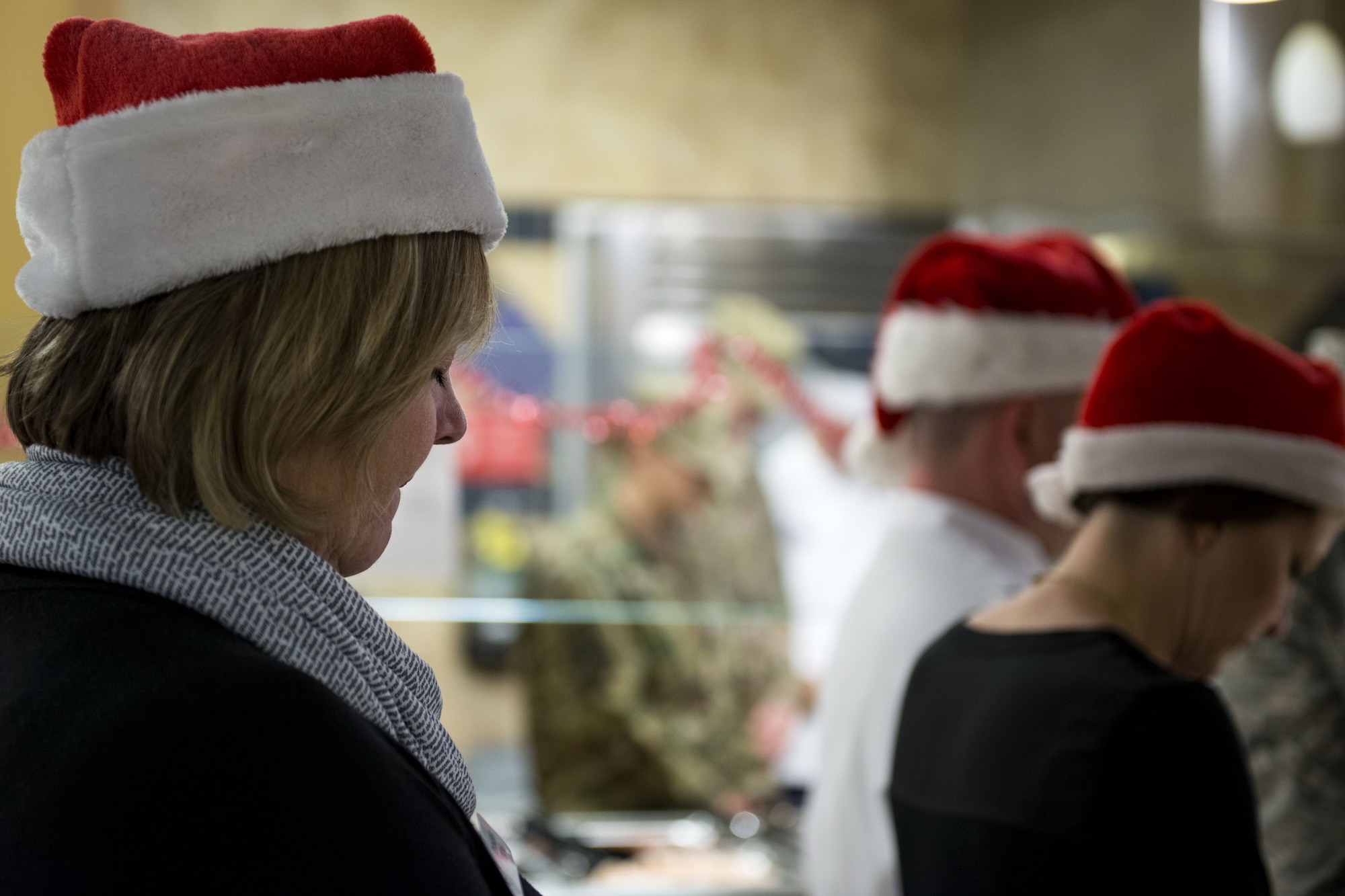 Airmen and families bow their heads during an opening prayer on Christmas Day in the Georgia Pines Dining Facility, Dec. 25, 2017, at Moody Air Force Base, Ga. The Christmas meal was an opportunity for Airmen, retirees, dependents and leadership to enjoy a traditional Christmas meal. (U.S. Air Force photo by Airman 1st Class Erick Requadt)