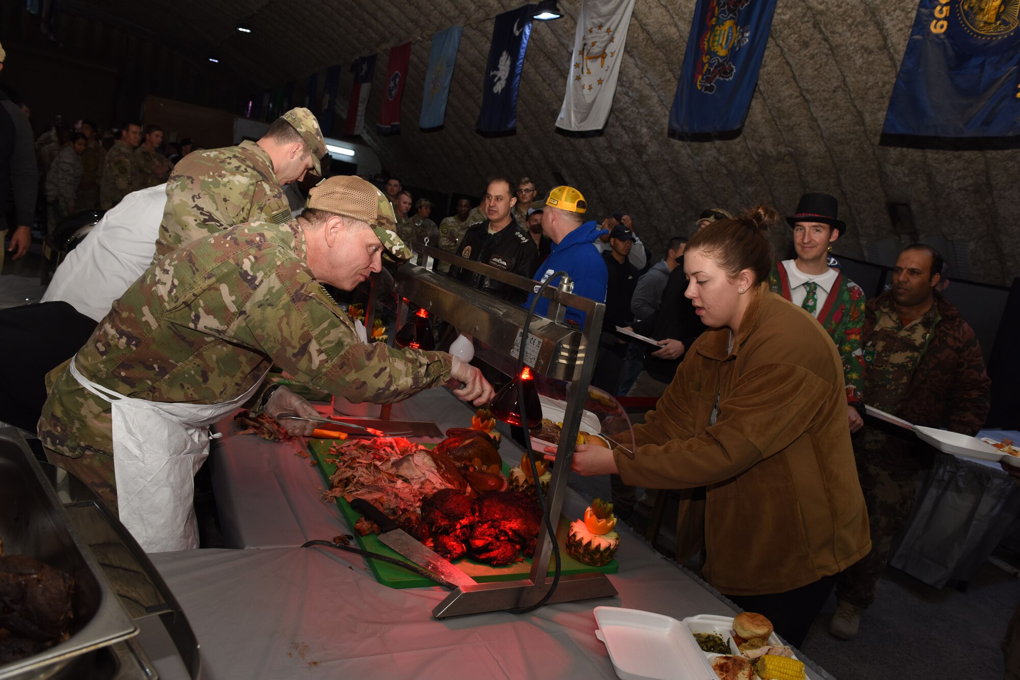 Brig. Gen. Kyle Robinson, 332nd Air Expeditionary Wing commander, serves portions of turkey to service members during a Christmas Day feast, Dec. 25. 2017 in Southwest Asia. Robinson was joined by other members of installation leadership in treating deployed service members to a traditional home-style meal while they're deployed in the region supporting Operation Inherent Resolve. (U.S. Air Force photo by Staff Sgt. Joshua Kleinholz)