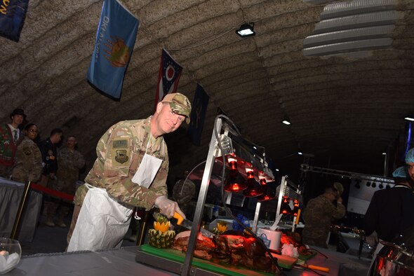 Brig. Gen. Kyle Robinson, 332nd Air Expeditionary Wing commander, carves the first turkey before a Christmas Day feast, Dec. 25. 2017 in Southwest Asia. Robinson was joined by other members of installation leadership in treating deployed service members to a traditional home-style meal while they're deployed in the region supporting Operation Inherent Resolve. (U.S. Air Force photo by Staff Sgt. Joshua Kleinholz)