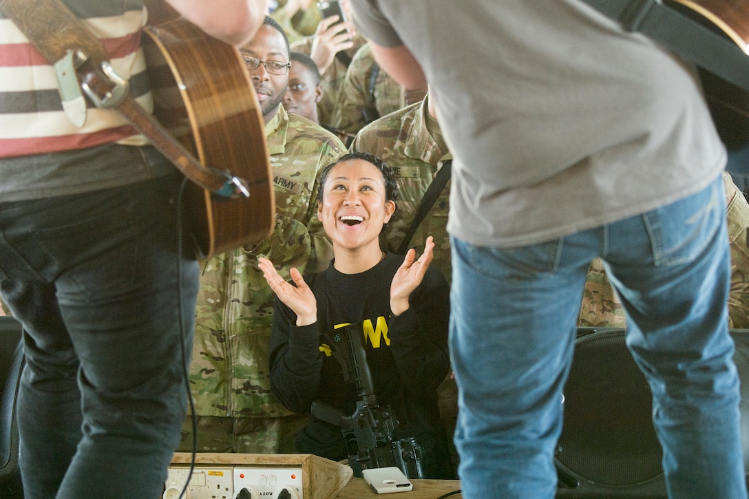 A soldier claps to music played by country artists.