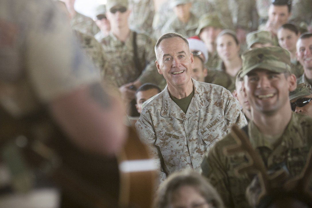 Marine Corps Gen. Joe Dunford listens to music in a crowd of service members.