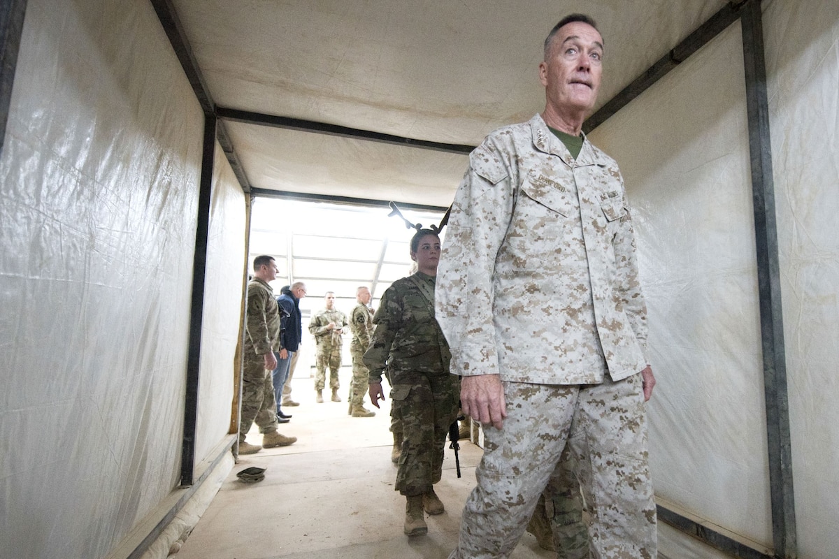 The chairman of the Joint Chiefs of Staff walks through a tunnel.