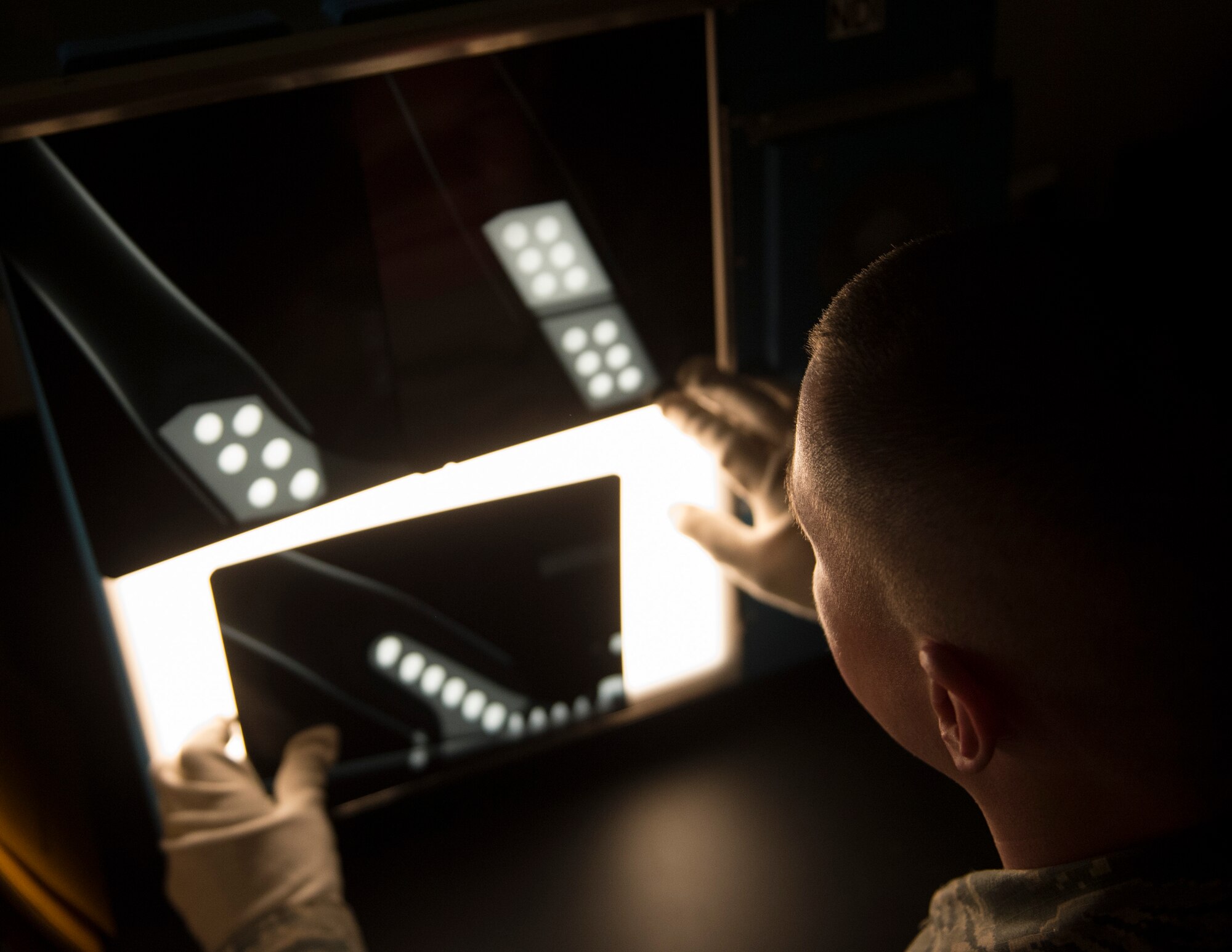 U.S. Air Force Staff Sgt. Nathan Schwalbach, 133rd Maintenance Squadron, inspects a photo negative of an aircraft equipment in St. Paul, Minn., Feb. 26, 2017.