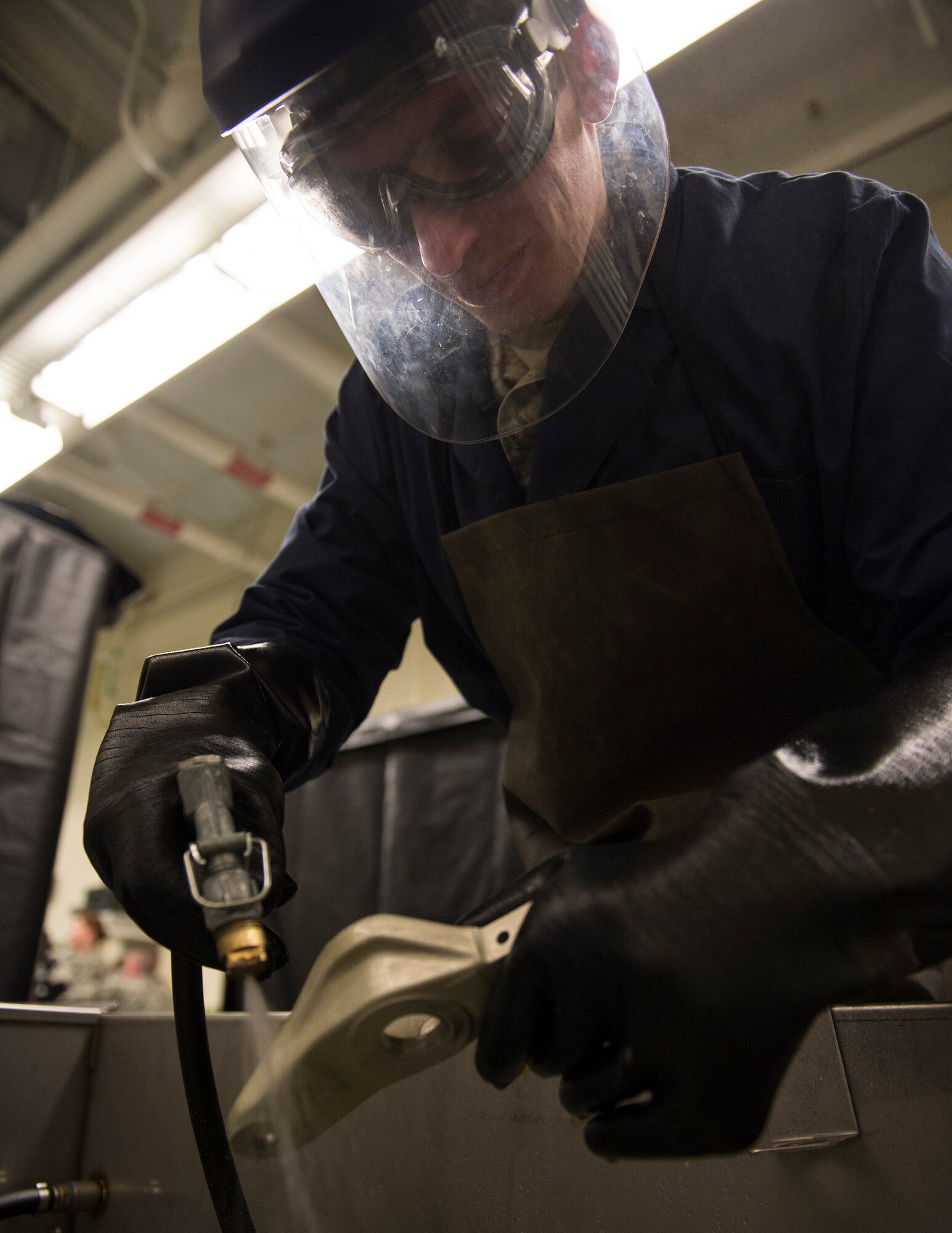 U.S. Air Force Staff Sgt. Gavriel Depringer-Gottfried, 133rd Maintenance Squadron, washes off the dye penetrant from the tow-fitting arm in St. Paul, Minn., Feb. 26, 2017.